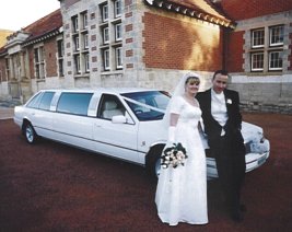 The happy couple in front of the limousine